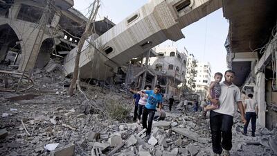 Palestinians walk past the collapsed minaret of a destroyed mosque in Gaza City on July 30 after it was hit in an overnight Israeli strike. AFP Photo