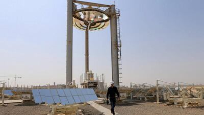 An employee walks at a solar plant in Masdar City. Another GCC country besides the UAE will go solar, says Robin Mills, the head of consulting at Manaar Energy. Karim Sahib / AFP