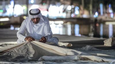 An Emirati fisherman sews a fishing boat sail. Victor Besa / The National