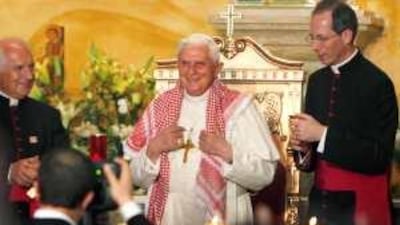 The Pope wears a kaffiyeh presented to him after he addressed the congregation at the Our Lady of Peace Church in Amman.