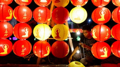 A worker installs lanterns before the Chinese Lunar New Year at a Buddhist temple in Jenjarom, Malaysia. Reuters