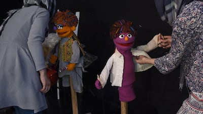 Afghan puppeteers Raziya Nazaria, left, and Mansoora Shirzad dress Sesame Street muppets Zeerak and Zari ahead of recording at a television studio in Kabul.