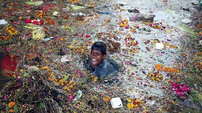 A child searches for coins under the polluted water of the river Tawi after Hindu devotees submerged a 'Saakh' depicting the Goddess Durga on the last day of Navratra, a Hindu festival in Jammu. Jaipal Singh / EPA