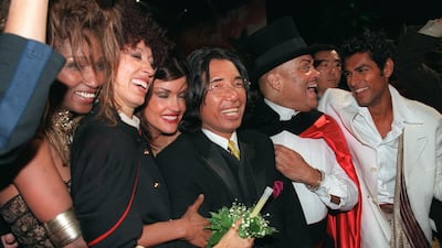 Fashion designer Kenzo, centre, surrounded by models, after showing his final collection on October 7, 1999. AFP