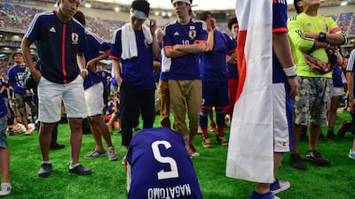 Japan football supporters are disappointed as Japan are defeated by Ivory Coast in the 2014 World Cup on Sunday. Yoshikazu Tsuno / AFP