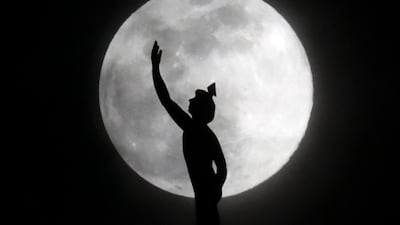 A statue of the Roman god Mercury, mounted on a hotel in Nashville, US, is silhouetted by the supermoon. AP Photo