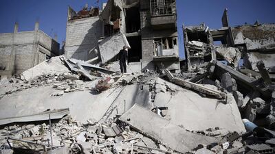 A man stands on the rubble of a damaged building at the besieged town of Douma, Eastern Ghouta, Damascus, Syria on March 5, 2018. Bassam Khabieh / Reuters