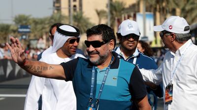 Diego Maradona waves to the crowd ahead of the finish of the fourth stage of the Dubai Tour cycling race in Dubai in 2014.