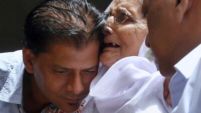 Abdul Aziz Sheikh, left, father of Sabika Sheikh, a victim of a shooting at a Texas high school, comforts to an elderly woman arriving for condolence to his daughter at his home in Karachi, Pakistan, Saturday, May 19, 2018. AP / Fareed Khan