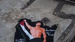A mural painted by Palestinian artists depicts US singer Dan Reynolds, lead vocalist of pop-rock band Imagine Dragons, alongside a Palestinian flag on the wall of a damaged building in Gaza city. EPA