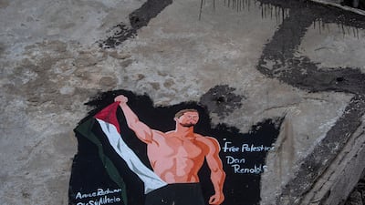 A mural painted by Palestinian artists depicts US singer Dan Reynolds, lead vocalist of pop-rock band Imagine Dragons, alongside a Palestinian flag on the wall of a damaged building in Gaza city. EPA