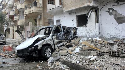 The wreckage of a car sits next to debris following an alleged air strike on December 20, 2014 by regime forces on the Syrian city of Raqqa. AFP