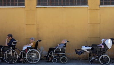Elderly residents, who spent the night in a sports hall converted into a shelter after being evacuated due to a wildfire threat, wait to be transferred to their permanent care home, in Fermoselle, Spain. Reuters