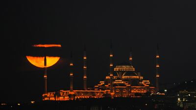 The harvest moon appears suspended over Camlica Mosque in Istanbul, Turkey. AP