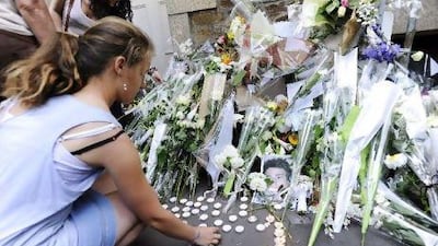 People set flowers in front of the house where the five Dupont de Ligonnes family members were murdered in the French city of Nantes. French authorities issued an international search alert on April 23 for murder suspect Xavier Dupont de Ligonnes amid evidence that he carefully planned the killing of his wife and four children.