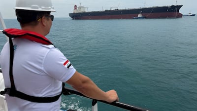 A sailor observes an oil tanker moored at one of Iraq's southern offshore terminals on April 24. Seafarers are essential, yet maritime law and frameworks seem unable to cope with how the conflict in Gulf waters affects their lives. Reuters