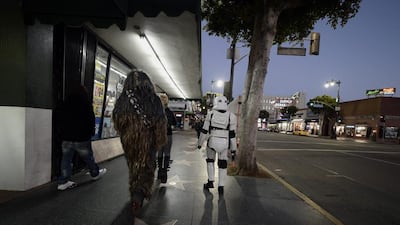 Chewbacca, left, and a Stormtrooper, centre, members of the Hollywood Storm Troopers group, head home after an afternoon of posing for pictures on Hollywood Boulevard before the premiere of Star Wars: The Force Awakens at the TCL Theatre in Hollywood, California. Paul Buck / EPA