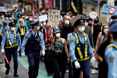 People wearing masks hold placards during a protest march over the alleged police abuse of a Turkish man, in echoes of a Black Lives Matter protest, following the death of George Floyd who died in police custody in Minneapolis, in Tokyo, Japan. Reuters