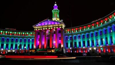 With the aid of a slow shutter speed, the lights of vehicles blur as motorists pass the traditional holiday light display illuminates the Denver City/County Building Saturday. David Zalubowski / AFP Photo
