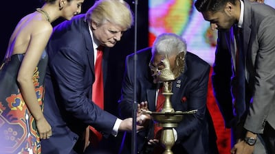 Republican presidential candidate Donald Trump is helped to light a ceremonial candle by Shalli Kumar during a charity event hosted by the Republican Hindu Coalition in Edison, New Jersey. Julio Cortez / AP Photo