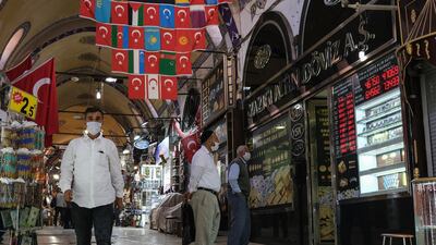 Men check rates on a board of a currency exchange office at the historical Grand Bazaar, in Istanbul, Turkey. EPA