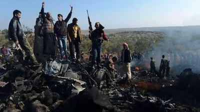 Syrian rebels celebrate on top of the remains of a government fighter jet which was shot down at Daret Ezza, on the border between the provinces of Idlib and Aleppo, on Wednesday.