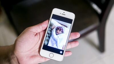 Rhodora Tindugan holds a photo of her son, Timothy, whose death led to weeks of heartbreak and worry over paperwork and expense before he was cremated in the Philippines. Reem Mohammed / The National