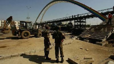 Soldiers watch the rebuilding yesterday of a footbridge that collapsed last week outside Jawaharlal Nehru Stadium.