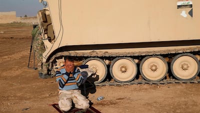 A member of the Iraqi army prays during clashes with Islamic State militants, north of Mosul, Iraq.