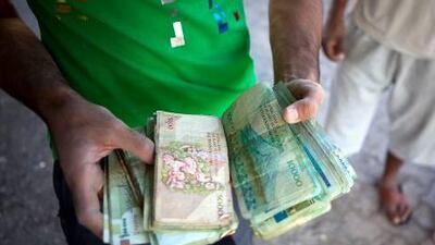 Iranian traders in a Musandam souq count the proceeds from their day's trade.