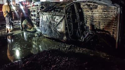 A pro-government Yemeni fighter stands next to a car in the area where Maj Gen Thabet Jawas and others were killed in Aden, Yemen, on March 23. AFP