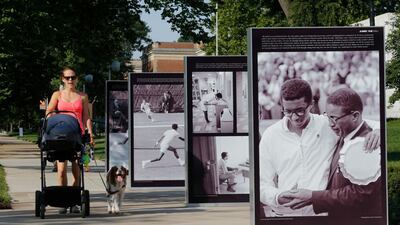A passerby walks by photographs of tennis star Arthur Ashe, part of an exhibition called Determined: The 400-Year Struggle for Black Equality, at Virginia Museum of History and Culture in Richmond. Steve Helber / AP