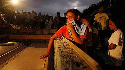 Relatives weep during a mass burial for victims of Friday’s flash flooding at a public cemetery in Iligan city yesterday.