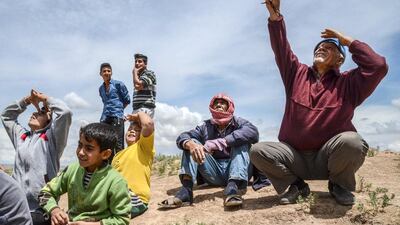 People look on as war-planes carry out bombings nearby in Kilis, Turkey. Ilyas Akengin / AFP