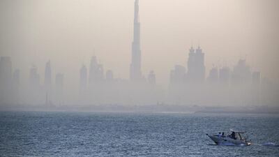 A boat passes by the skyline of downtown Dubai. Jon Gambrell / AP Photo