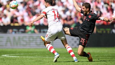 Cologne defender Jonas Hector and Bayern Munich's forward Thomas Mueller vie for the ball. AFP