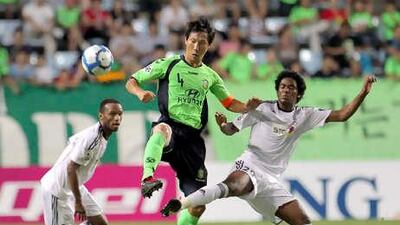 Al Shabab's Fahad Hamad, right, fights for the ball against Jeonbuk Motors's Kim Sang-sik.
