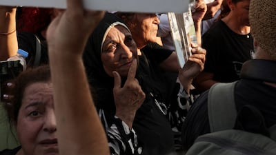 People hold pictures as they gather to mark the sixth anniversary of the Beirut port explosion in Beirut. Reuters