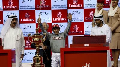 Victor Espinoza, who competed with California Chrome from USA, celebrates as he receives the trophy after winning the ninth and final race. REUTERS/Ahmed Jadallah