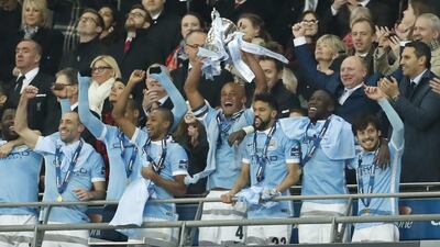 Manchester City’s Vincent Kompany celebrates winning the Capital One Cup Final with the trophy and teammates. Action Images via Reuters / John Sibley