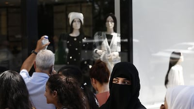 Like tourists queuing to buy luxury goods, so are companies taking advantage of the Turkish lira's fall to a record low, by buying back debt. Lefteris Pitarakis / AP