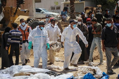 Palestinian health workers recover bodies from a mass grave at Nasser Hospital compound in Khan Younis. Bloomberg