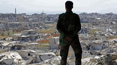 A Syrian soldier looks out over the town of Harasta in Eastern Ghouta on March 29, 2018, two weeks after it was retaken from rebels following heavy bombardment. AFP