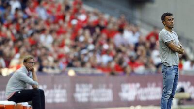 Liverpool manager Jurgen Klopp, left, and Barcelona manager Luis Enrique observe from the touchline. Frank Augstein / AP Photo
