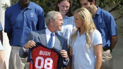 The US President George W Bush receives a softball jersey from the Team USA softball pitcher Jennie Finch