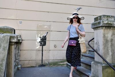 A woman walks by an artwork attributed to Banksy in Paris's 18th arrondissement in June 2018. EPA
