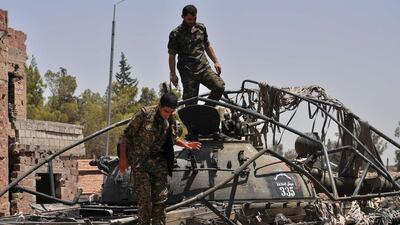 Kurdish fighters stand on top of a tank bearing the ISIL logo in the northeastern Syrian province of Hassakeh on July 26, 2015. Delil Souleiman/AFP Photo