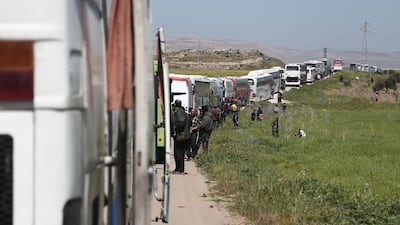 A convoy transporting Syrian civilians and rebel fighters evacuated from Eastern Ghouta waits in a government-held area prior to entering the village of Qalaat al-Madiq, some 45 kilometres northwest of the central city of Hama, on March 26, 2018, as evacuations from the opposition enclave continued following a deal that was announced earlier in the week. Abdulmonam Eassa / AFP
