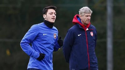Arsene Wenger, right, is optimistic Mesut Ozil will return to form. Eddie Keogh / Reuters
