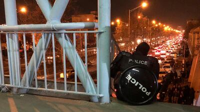 A riot police officer watches a protest in Tehran on January 12, 2020 over the shooting down of a passenger plane by the Iranian military. AP Photo